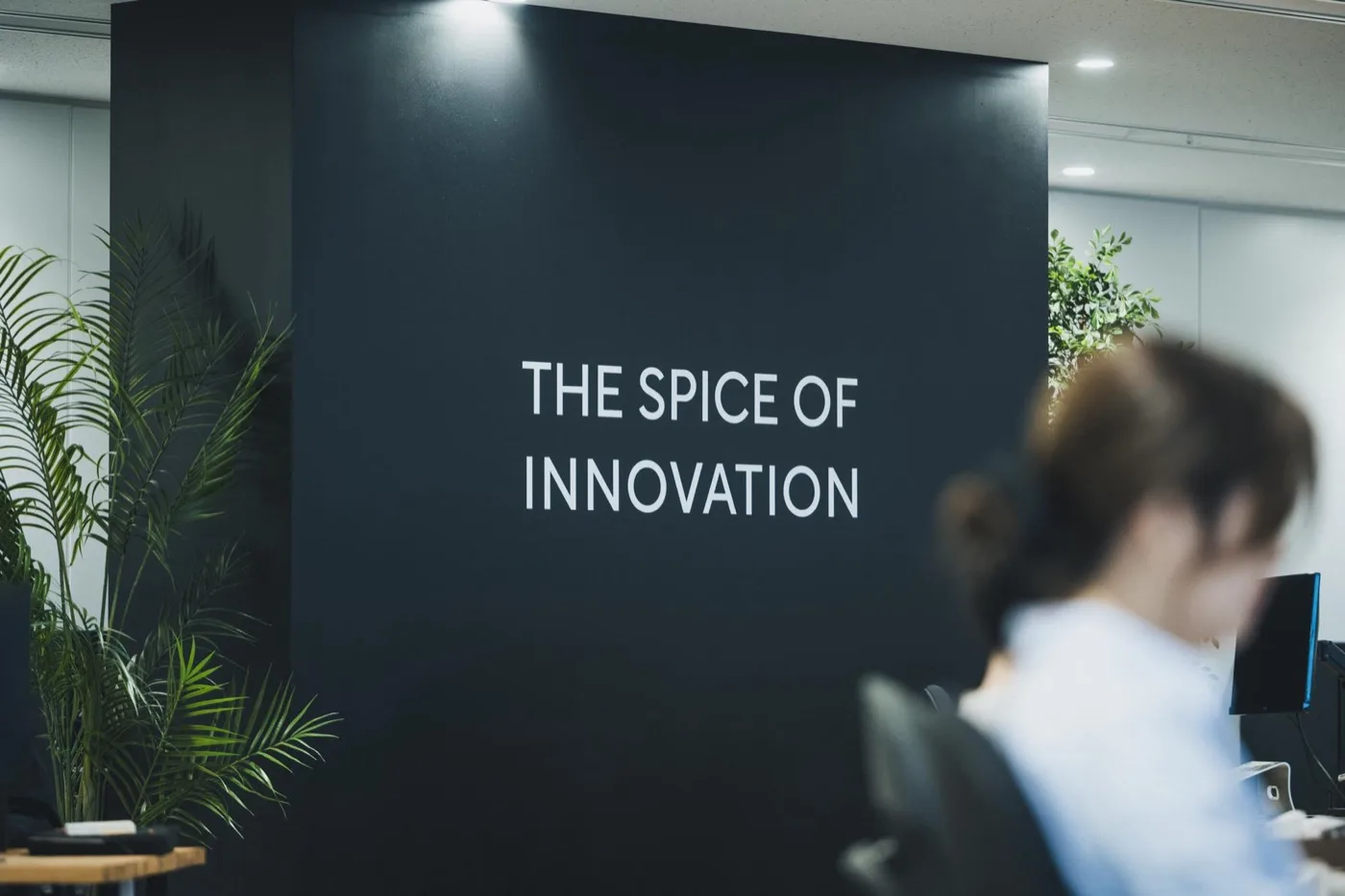 THE SPICE OF INNOVATION の壁面の前で作業に集中するスパイスファクトリーのメンバー